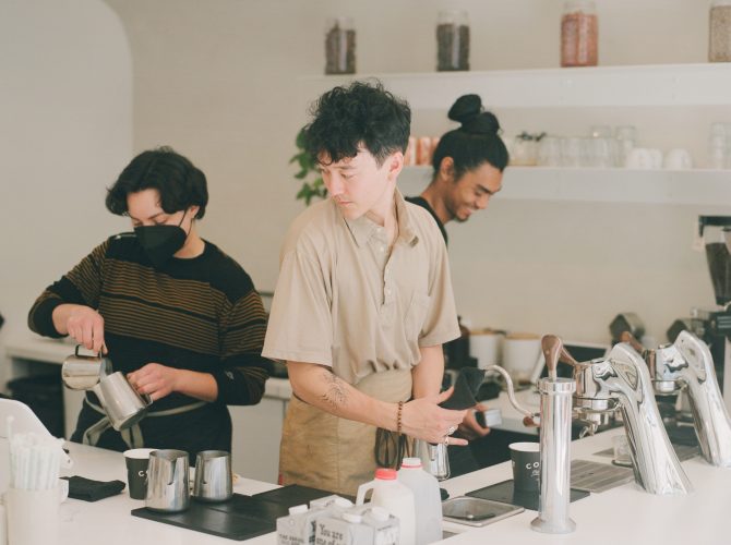Baristas making drinks in a cafe on a Modbar