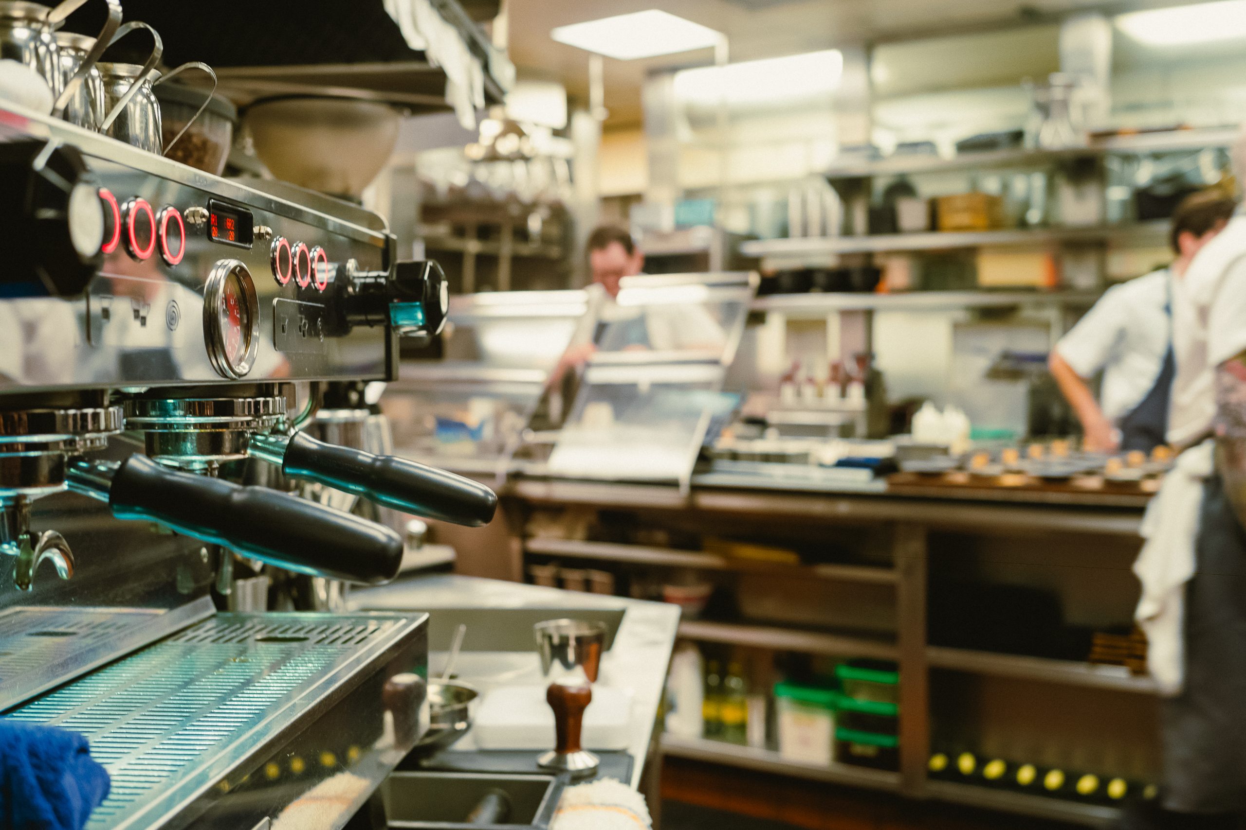 the espresso machine in the ktichen with the prep table in the background