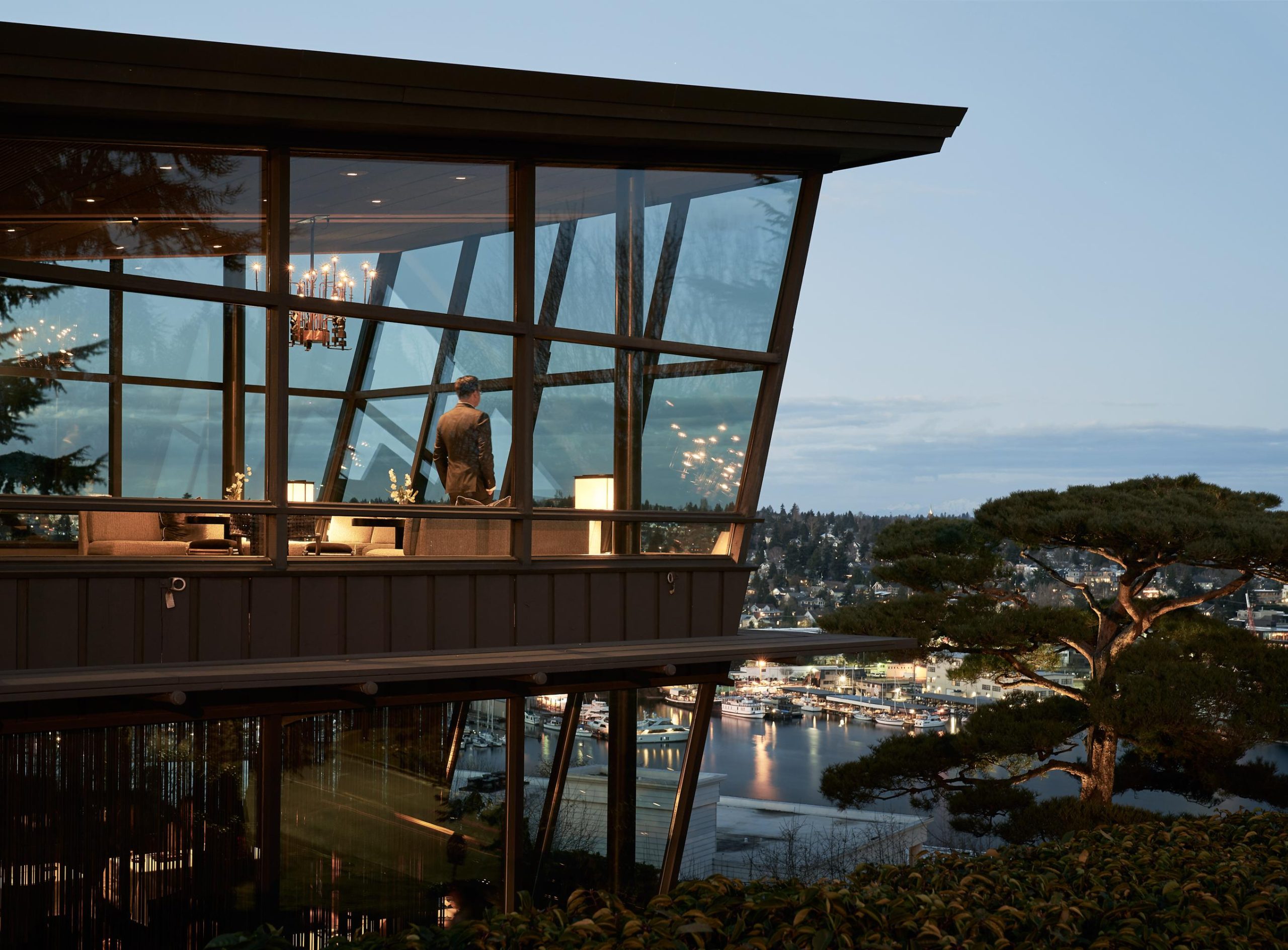 the exterior of the Canlis restaurant, a modern building with wide glass windows overlooking a lake