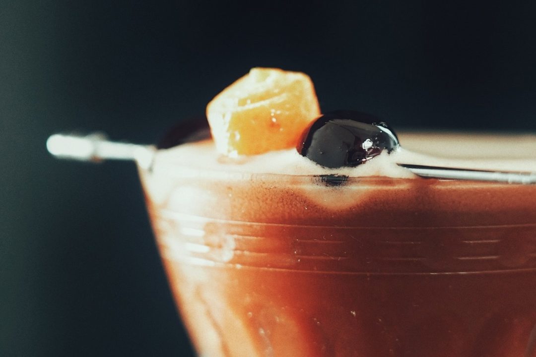 a close up of a signature coffee drink with a fruit garnish