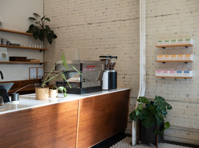 a coffee counter with a la marzocco espresso machine and two grind-by-sync grinders