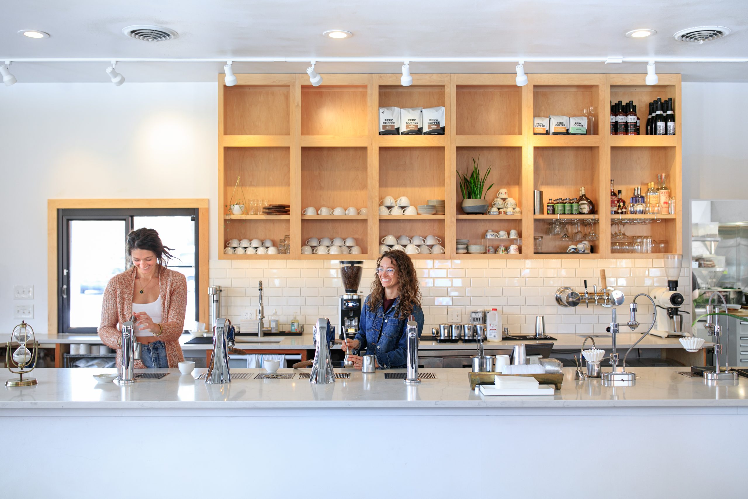 the owners of fiddlehead fern cafe behind the counter of their coffee bar