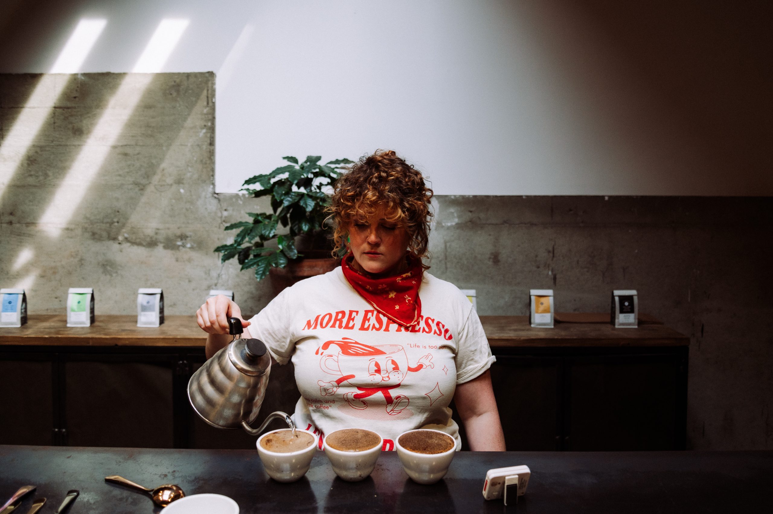 a woman preparing a flight of coffees for cupping