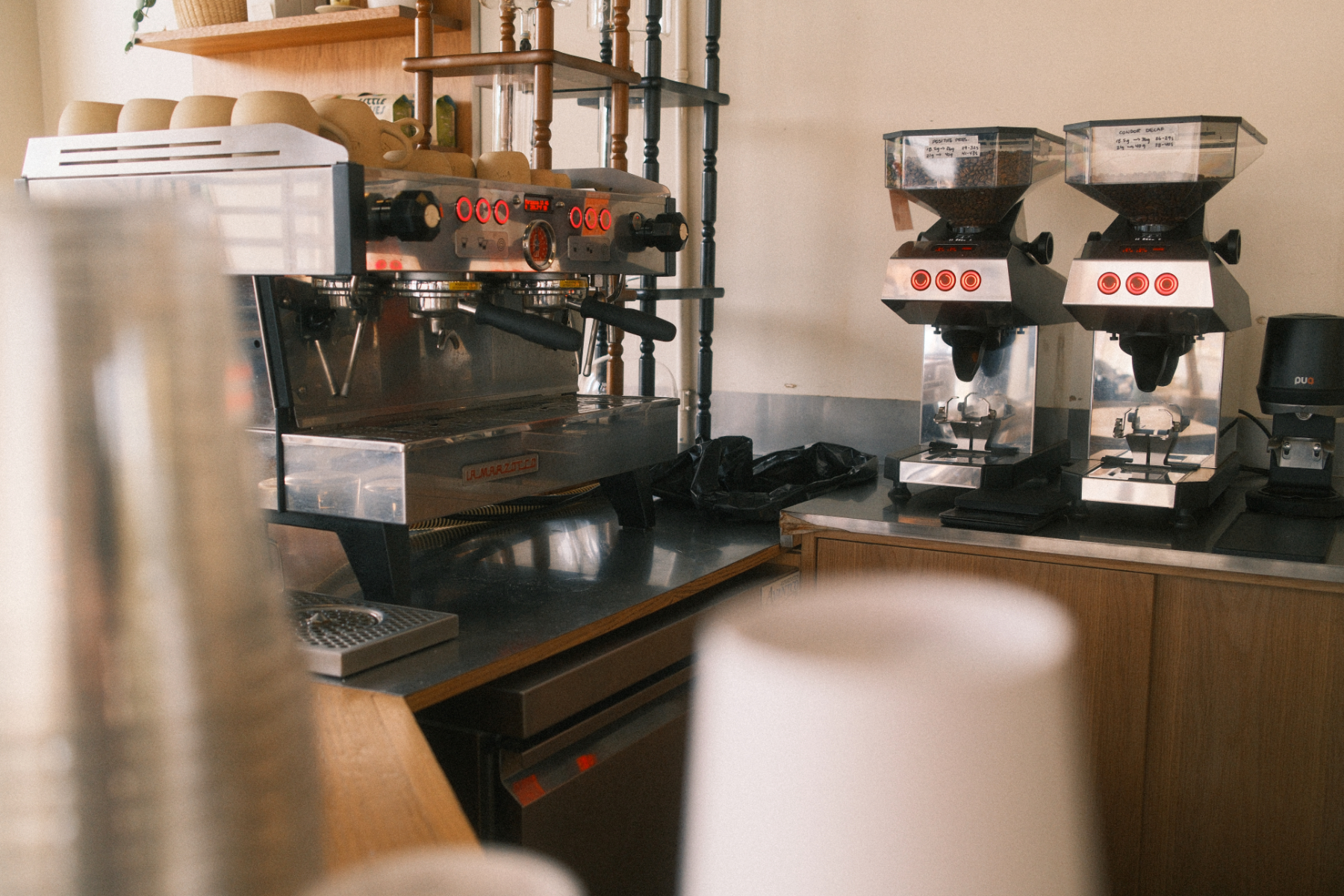 behind the bar at loba coffee + pastry showing a linea pb and two swans