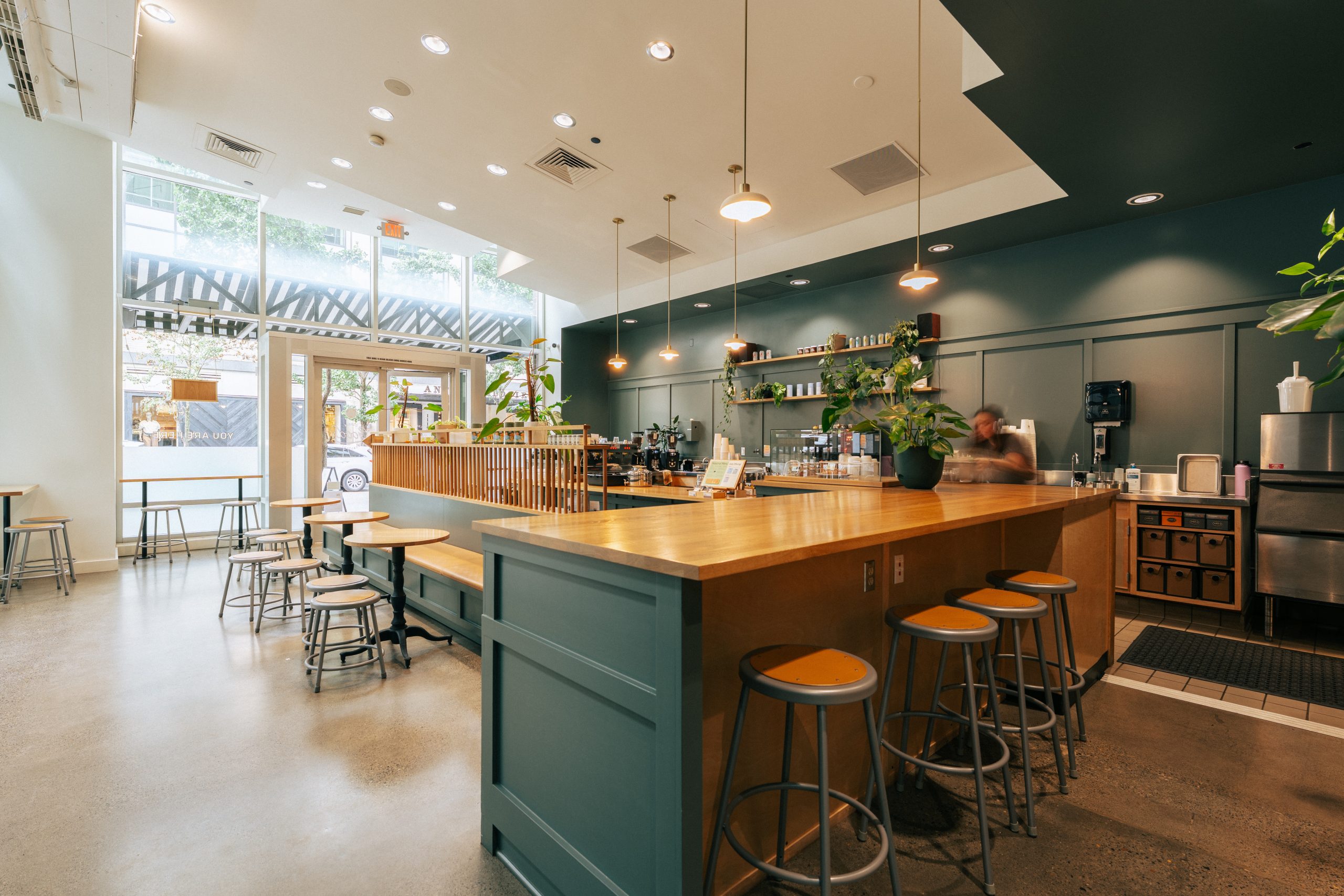 the interior of a good coffee location showing counter seating and a coffee bar in the background