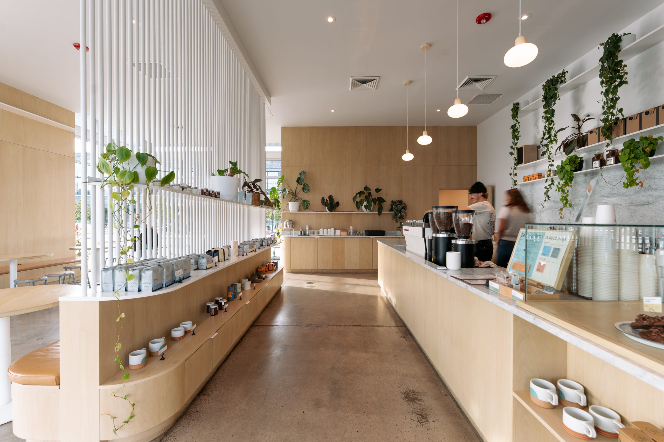 the interior of a good coffee location with a coffee bar on the right and retail shelves on the left